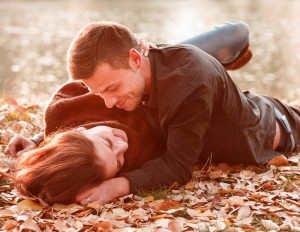 young couple lying down smiling